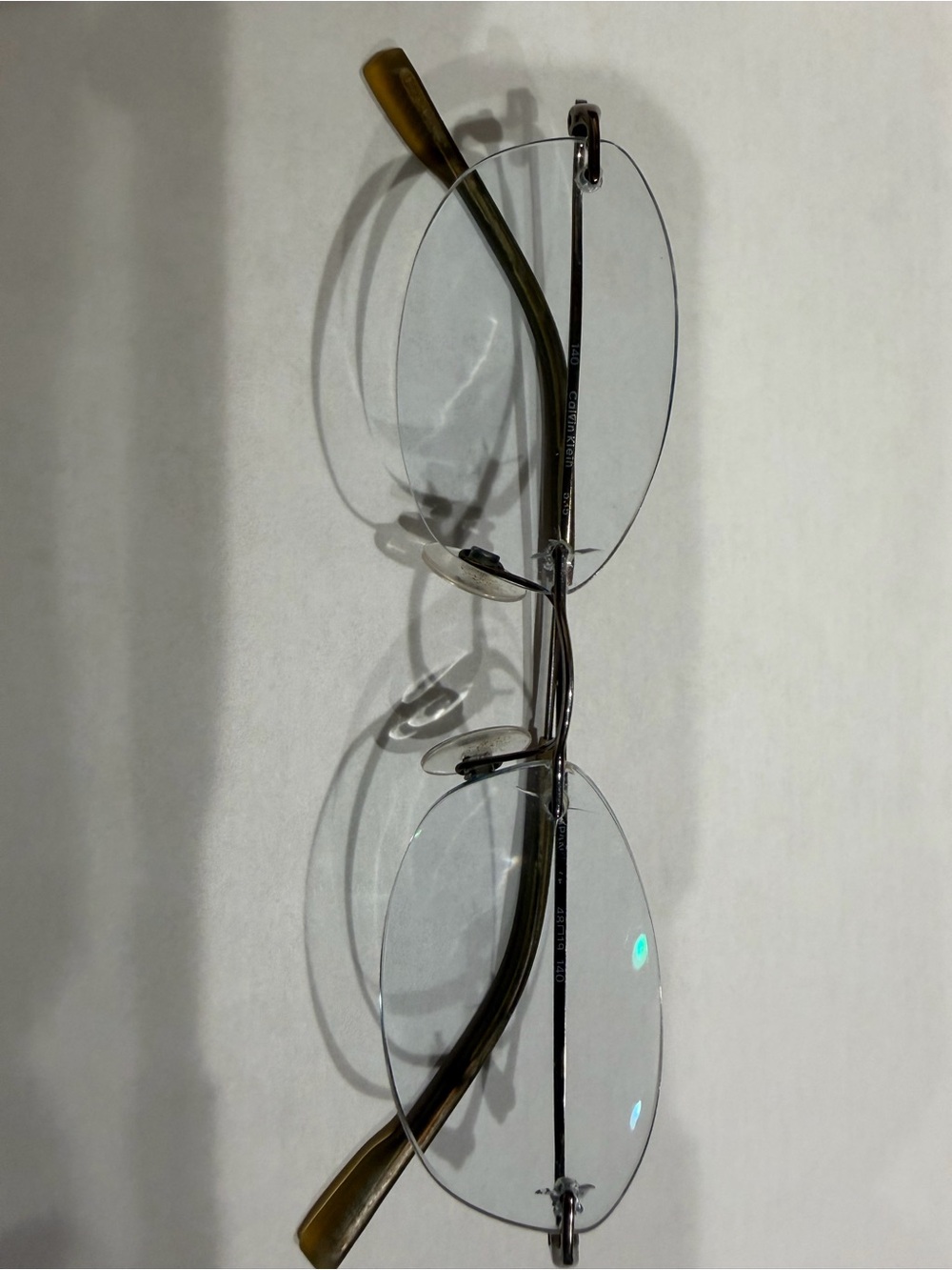 Calvin Klein Rimless Oval Glasses with titanium Frame and Brown Temple Tips